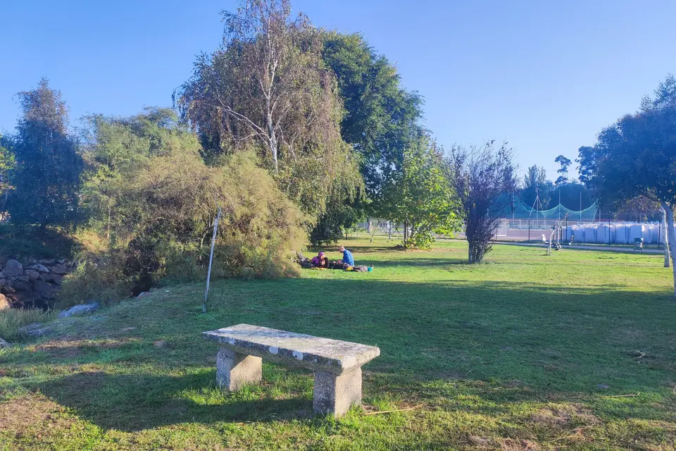 Stone bench in a green park with trees, a shaded rest stop on a bike ride