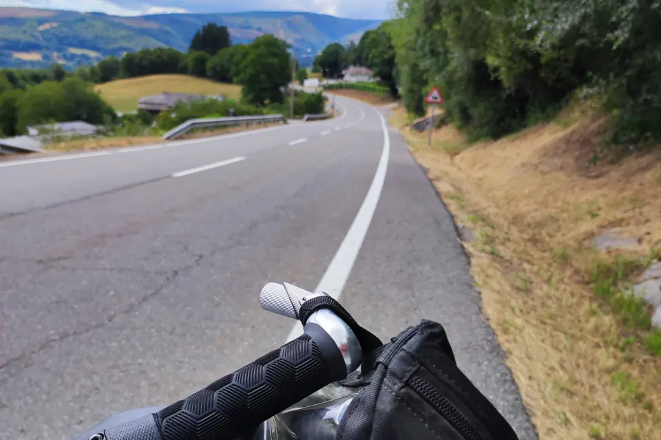 Rider's view over the handlebar on a road with a wide white line