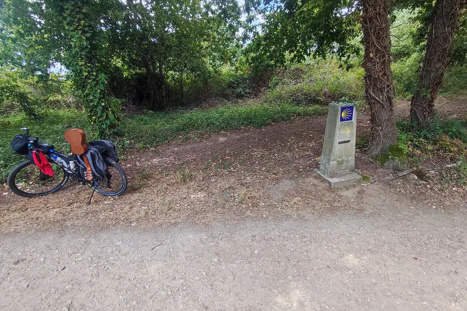Bike leaning near an information totem on a shaded cycle path