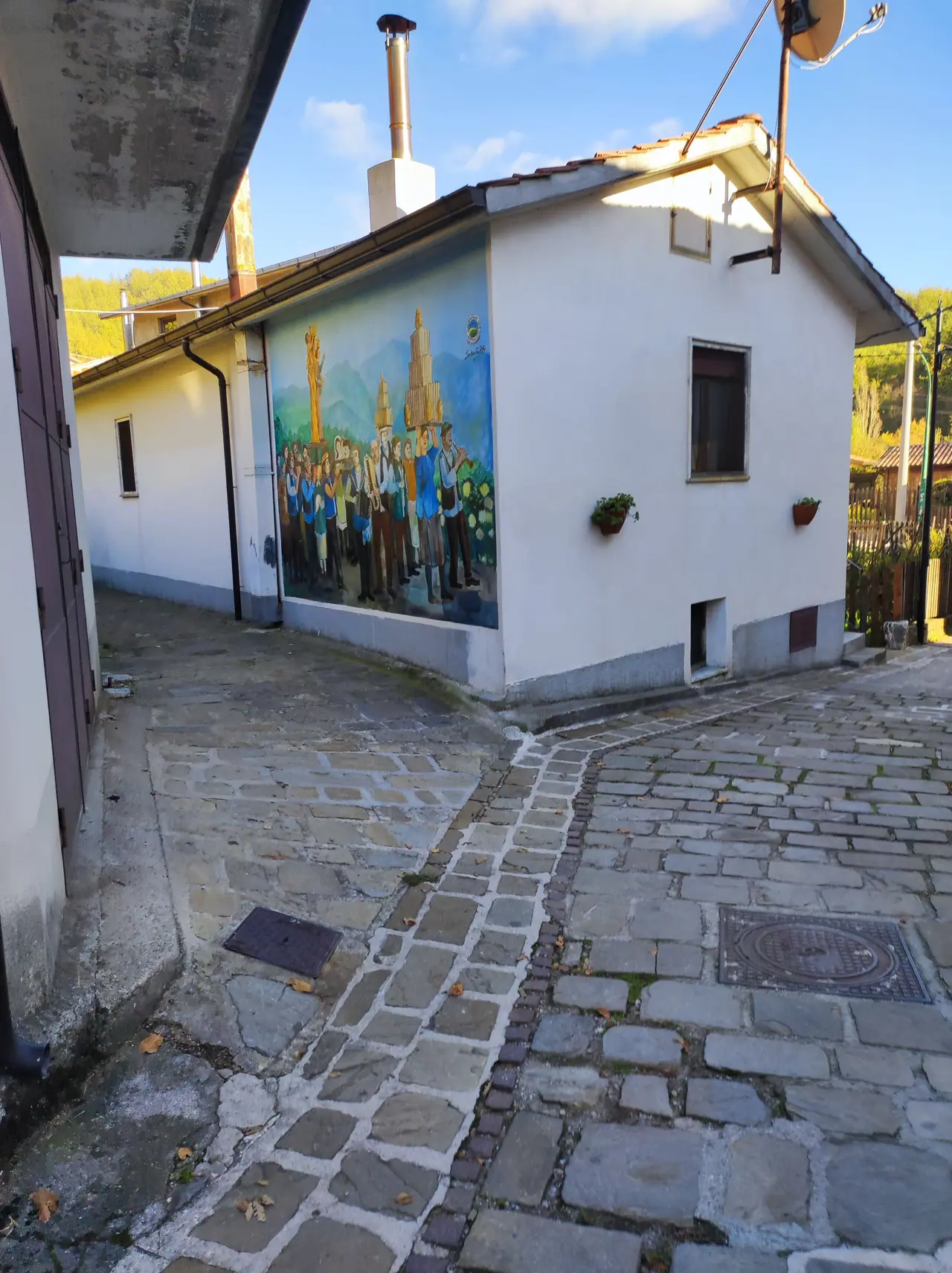 Quiet lane paved in pale stone between whitewashed houses in a southern village