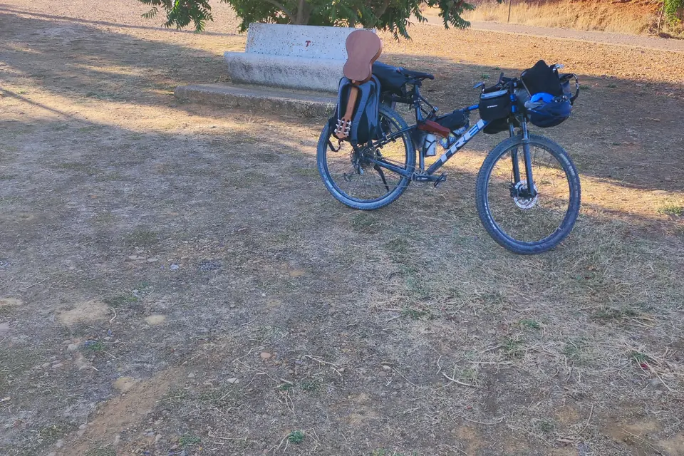 Beladenes Gravelbike am staubigen Rand einer Landstraße