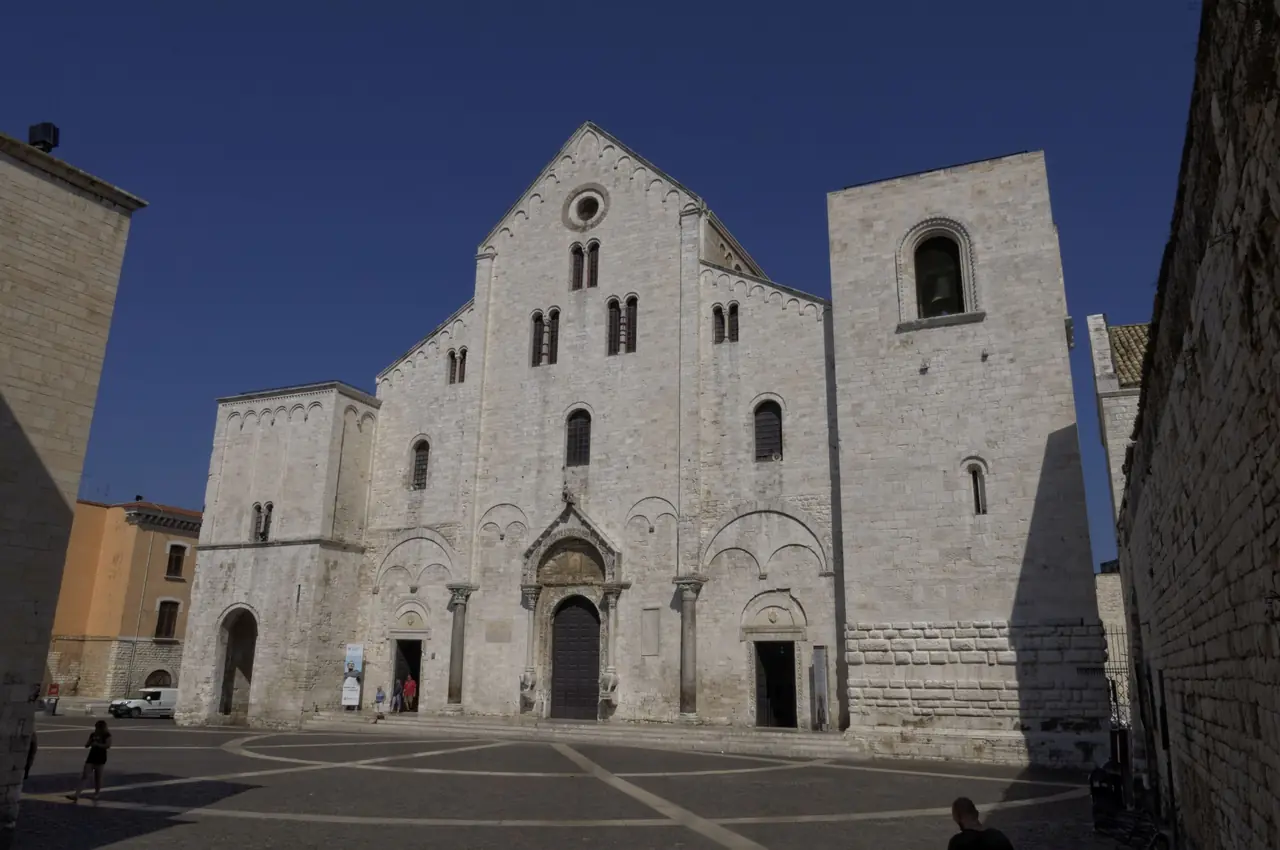 The stone facade of the Basilica di San Nicola in Bari Vecchia seen from the square in front of it