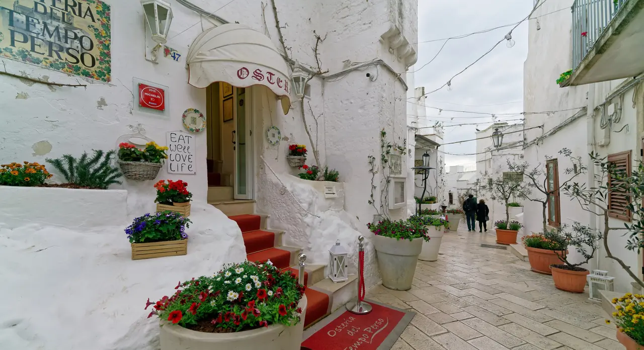 Stepped alley between white lime-washed walls in the historic centre of Ostuni, in Puglia's Valle d'Itria