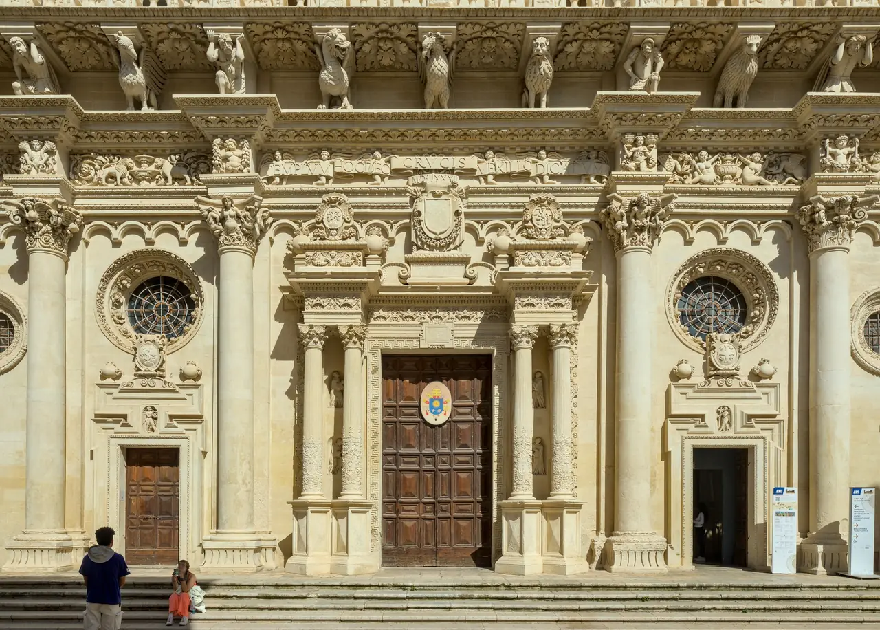 The Baroque facade of the Basilica di Santa Croce in Lecce with its large rose window and carved Lecce stone decoration